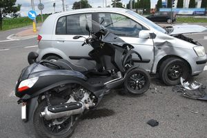 motorower stojący obok uszkodzonego samochodu