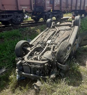 uszkodzony samochód marki Opel Astra w tle wagony pociągu towarowego