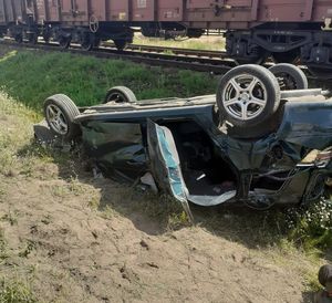 uszkodzony samochód opel astra w tle wagony pociągu towarowego