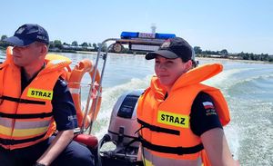 policjant i funkcjonariuszka straży pożarnej na łodzi