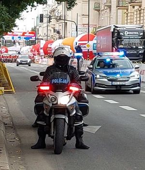 eskorta policyjna na motocyklu, radiowóz, a za nim peleton
