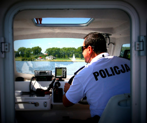 policjant siedzi w łodzi motorowej