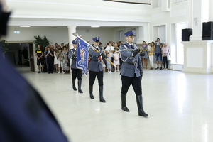 Funkcjonariusze pocztu sztandarowego wchodzą na salę w której odbywa się ślubowanie policjantów.