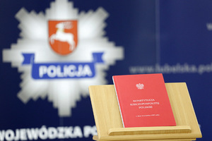 Na pierwszym planie zdjęcia po prawej stronie Konstytucja Rzeczpospolitej w drugim planie zdjęcia logo Lubelskiej Policji.