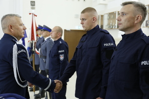 Komendant Wojewódzki Policji w Lublinie ściska dłoń policjanta i gratuluje wstąpienia do służby.