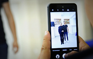 Zdjęcie telefonu komórkowego na ekranie którego widać nową policjantkę z rodziną.