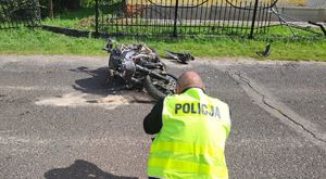 technik policyjny wykonujący zdjęcie leżącemu motocyklowi