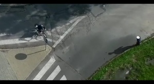 kadr z drona przedstawiający rowerzystę jadącego po przejściu dla pieszych