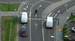 kadr z drona przedstawiający rowerzystę jadącego po przejściu dla pieszych