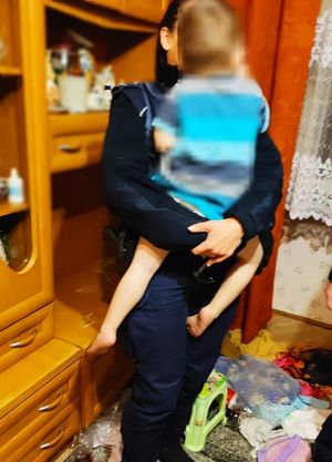 policjantka trzyma na rekach małego chłopca