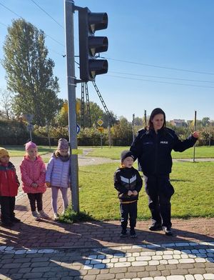policjantka wyjaśnia dzieciom jak prawidłowo przechodzić przez jezdnię
