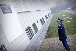 komendant wojewódzki stoi pod tablica Naszego Patrona