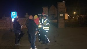 policjanci rozdają odblaski pod cmentarzem w porze wieczorowej