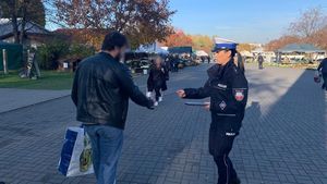 policjantka rozdaje odblaski pod cmentarzem