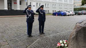 policjanci oddają hołd przed pomnikiem