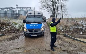 policjant przy drodze, obok radiowóz