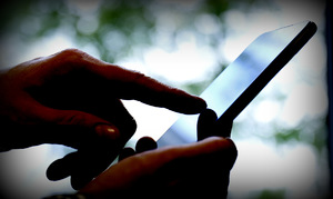 dłoń wskazuje palcem ekran smartfona