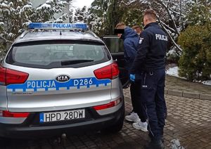 policjanci prowadzą zatrzymanego 37-latka do radiowozu