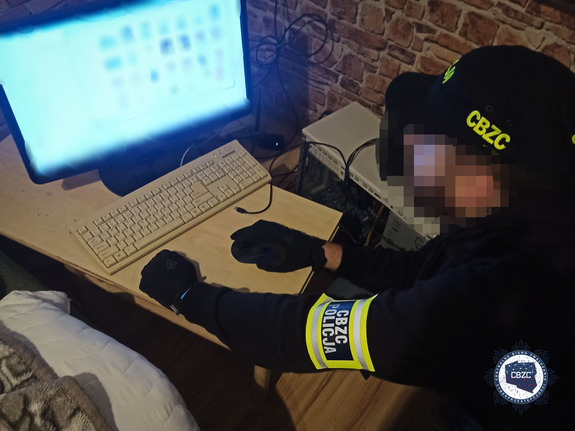 policjant operacyjny przed komputerem