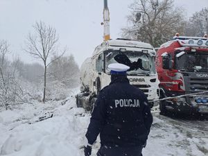 policjant na tle wyciąganej cysterny z rowu