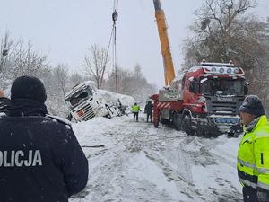 policjant na tle wyciąganej cysterny z rowu