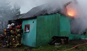 Akcja gaśnicza Straży Pożarnej przy palącym się domu