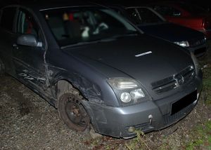 Uszkodzony Opel Vectra stoi na szutrowym podłożu