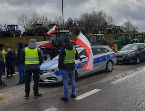 protestujący rolnicy na drodze, w tle radiowóz