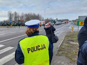 policjantka w kamizelce odblaskowej na tle protestu