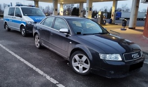 Samochód marki Audi stoi zaparkowany na stacji paliw,a za nim oznakowany radiowóz policyjny (1)