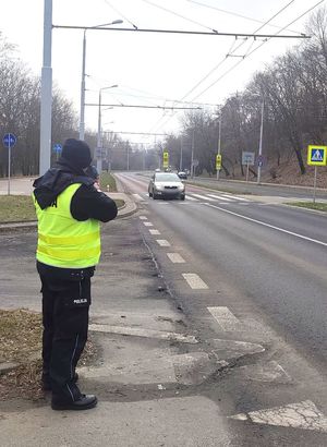 policjant kontroluje kierujących przy przejściu dla pieszych