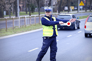 Policjant zatrzymuje pojazd do kontroli drogowej.