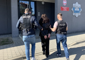 Policjanci prowadzą zatrzymaną kobietę do Komisariatu V Policji w Lublinie.