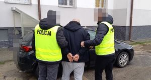 policjanci prowadzą zatrzymanego mężczyznę w kajdankach