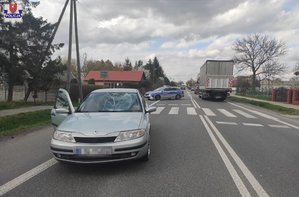 droga i stojący na jednym pasie ruchu osobowy Renault, za nim stoi policyjny radiowóz
