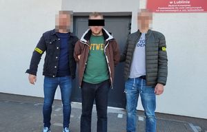 Zdjęcie przedstawia zatrzymanego mężczyznę oraz dwóch policjantów.