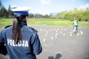 policjanta egzaminuje rowerzystę na torze przeszkód