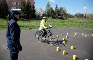 policjanta egzaminuje rowerzystę na torze przeszkód