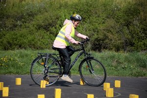 policjanta egzaminuje rowerzystę na torze przeszkód