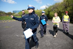 policjanta egzaminuje rowerzystę na torze przeszkód