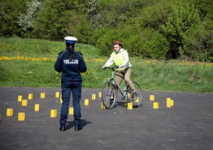 policjanta egzaminuje rowerzystę na torze przeszkód