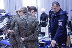 Policjant pokazuje mierniki prędkości jakie były używane w policji.