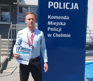 Na zdjęciu policjant Daniel Krysa. W tle komenda miejska policji w Chełmie