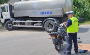 na zdjęciu pojazd ciężarowy i motocykl, który brał udział w zdarzeniu. Obok jednośladu stoi umundurowany policjant, który przeprowadza oględziny pojazdu.