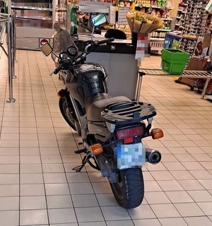 motocykl zaparkowany przy kasie w sklepie