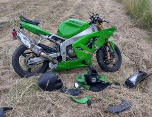 rozbity zielony motocykl na trawie