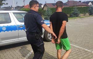 policjant prowadzi zatrzymanego mężczyznę