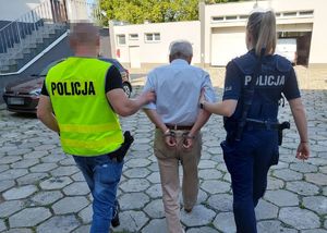 policjant z policjantką prowadzą zatrzymanego 72-latka
