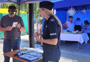policjantka i mężczyzna z alkogoglami na oczach czyta telst z kartki
