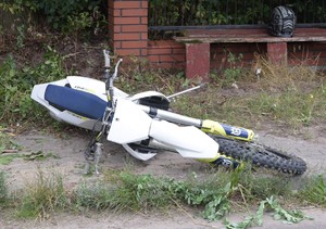 leżący na drodze uszkodzony crossowy motocykl